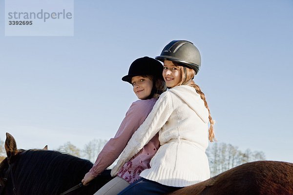 Zwei Mädchen auf einem Pferd