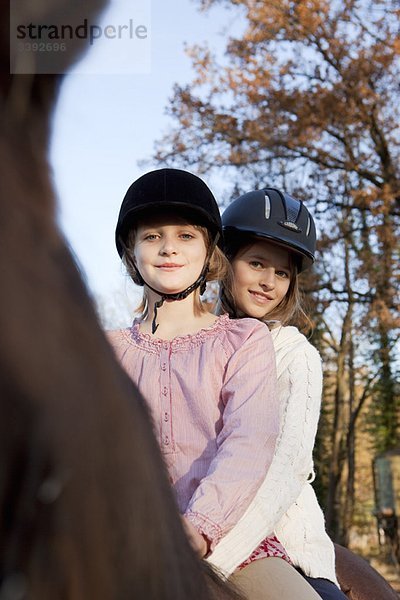 Zwei Mädchen auf einem Pferd