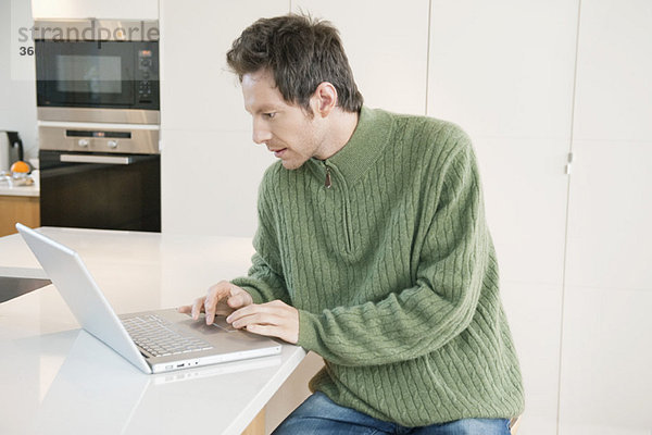 Mann arbeitet an einem Laptop