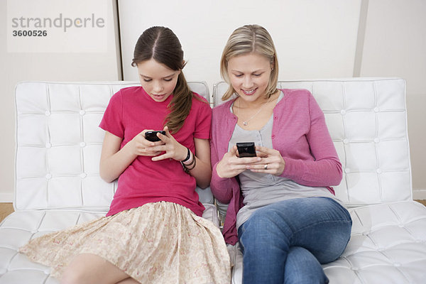 Frau mit ihrer Tochter SMS auf dem Handy