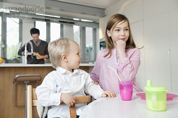 Mädchen am Frühstückstisch mit ihrem Bruder