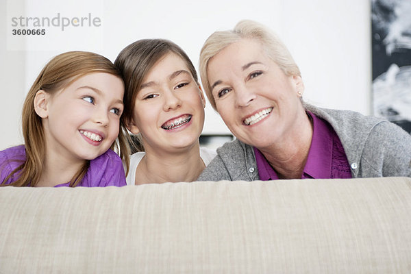 Porträt einer Frau,  die mit ihren Enkelinnen lächelt