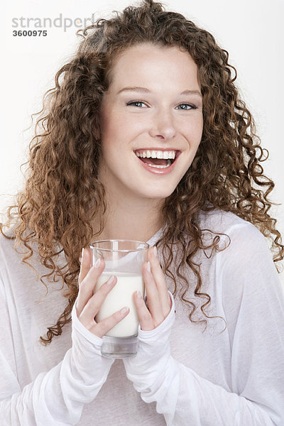Porträt einer Frau,  die ein Glas Milch hält und lacht