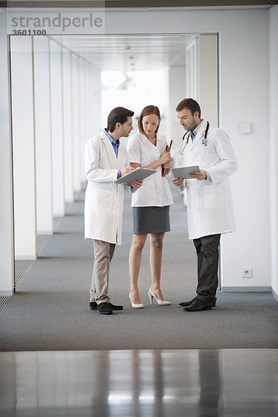 Drei Ärzte diskutieren über einen medizinischen Bericht