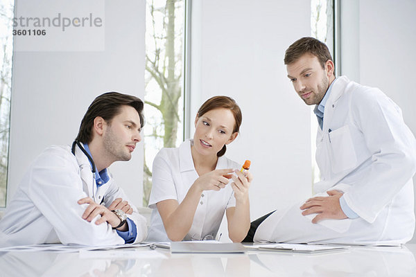 Drei Ärzte untersuchen die Medizin
