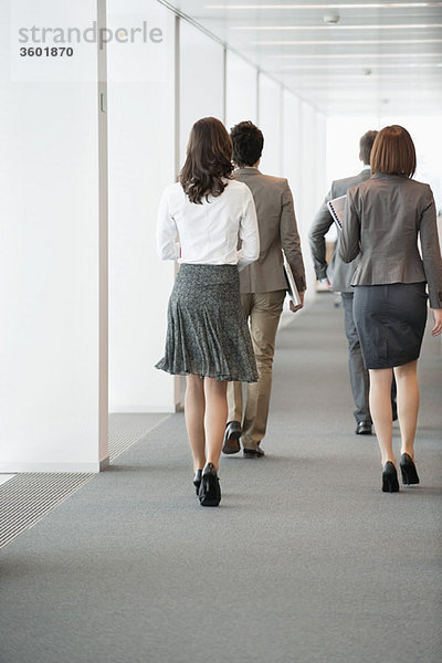 Geschäftsleute,  die im Flur eines Büros spazieren gehen