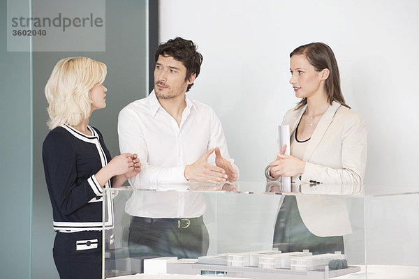 Mann mit zwei Frauen in der Nähe eines Architekturmodells