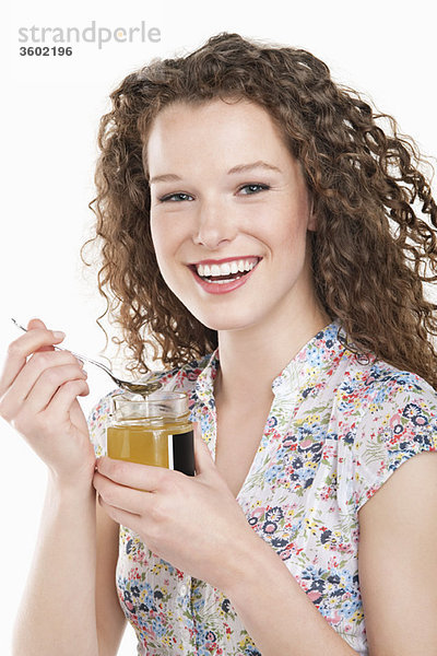 Porträt einer Frau beim Honigessen