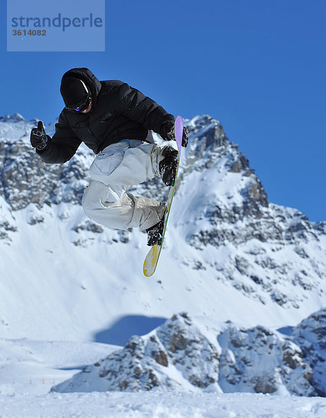 ein Freestyle Snowboarder berührt sein Board auf einen Sprung