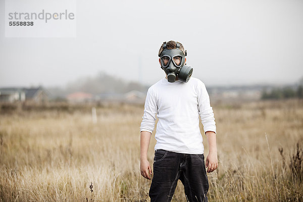 Junge mit Gasmaske im Weizenfeld