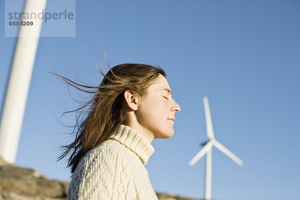 Profile of young woman,  wind turbines in background