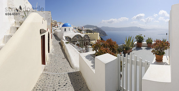 Griechenland,  Blick auf das Dorf Oia mit Kopfsteinpflasterweg und Tor bei Santorini