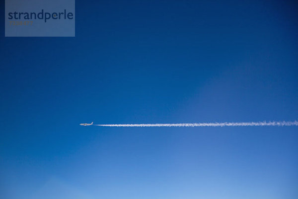 Ein Flugzeug und Kondensstreifen am Himmel