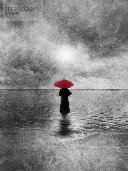Stimmungsvolle,  einsame Frau mit rotem Regenschirm geht ins Wasser
