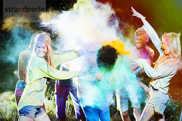 Freunde werfen Kreidefarbe auf den Menschen beim Musikfestival