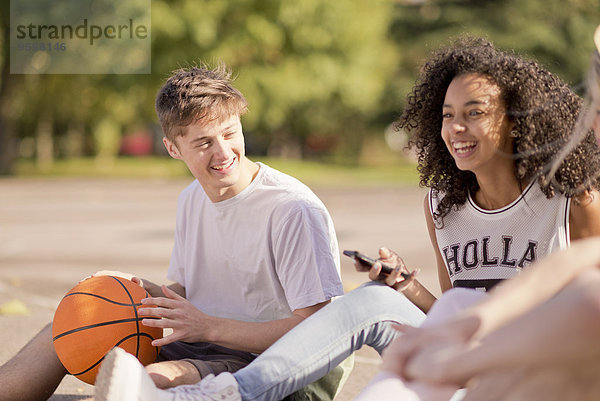 Gruppe junger erwachsener Basketballspieler beim Chatten