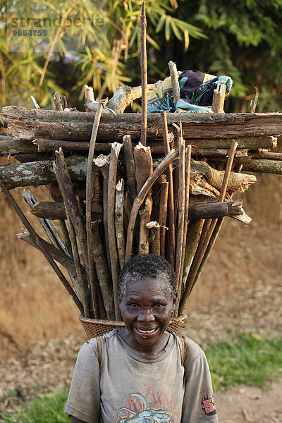 Alte Frau mit Feuerholz auf dem Rücken,  Kasongo-Lunda,  Kawangoregion,  Demokratische Republik Kongo