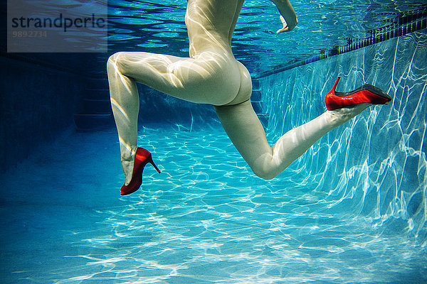 Reife Frau,  nackt,  nur mit roten High Heels,  Unterwasseransicht,  tiefer Schnitt