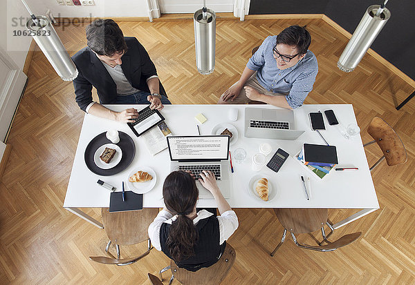 Drei kreative Geschäftsleute bei einem Meeting in einem modernen Büro