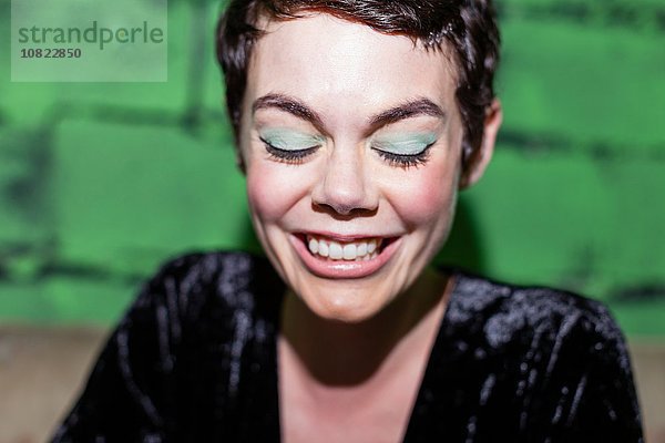 Mittlere erwachsene Frau mit grünem Lidschatten,  lächelnd