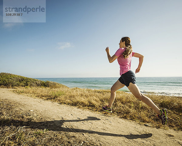 Kaukasische Frau joggt am Strand