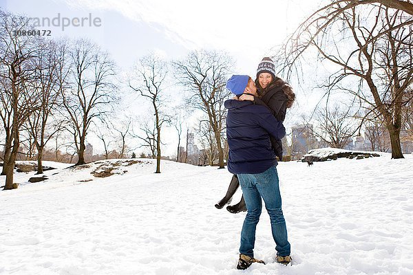 Romantischer junger Mann mit Freundin im verschneiten Central Park,  New York,  USA