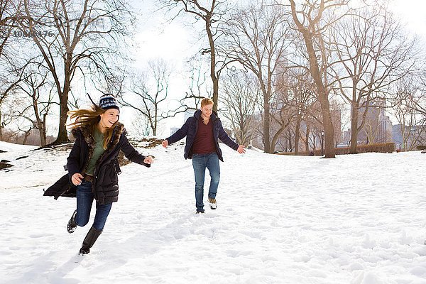 Junges Paar läuft im verschneiten Central Park,  New York,  USA