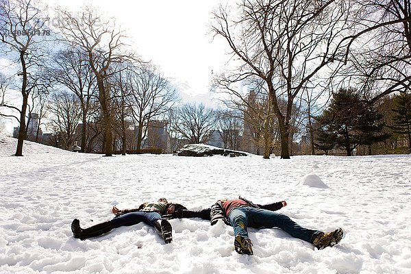 Junges Paar im verschneiten Central Park liegend,  New York,  USA
