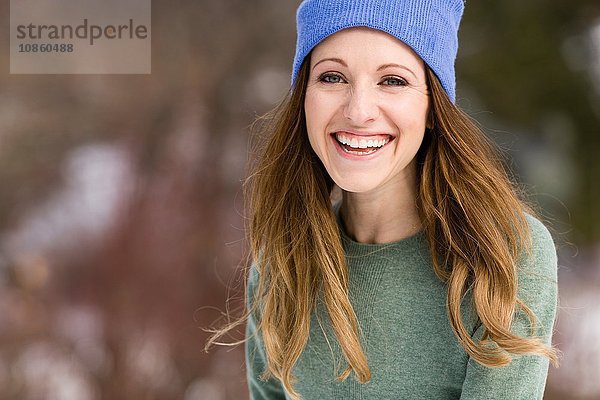 Porträt einer glücklichen jungen Frau mit Strickmütze