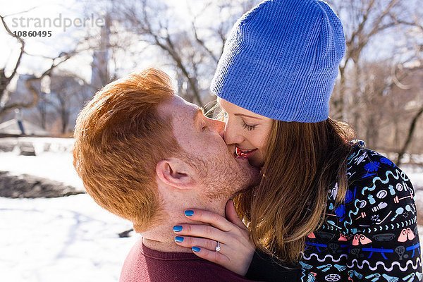 Romantisches junges Paar küsst sich im verschneiten Central Park,  New York,  USA