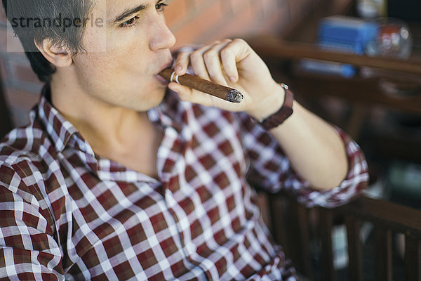 Mann,  der Zigarre raucht