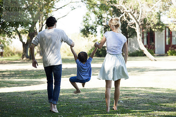 Familie mit einem Kind beim gemeinsamen Spaziergang im Freien
