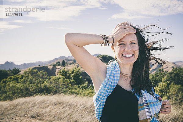 Lachende kaukasische Frau auf einem ländlichen Feld
