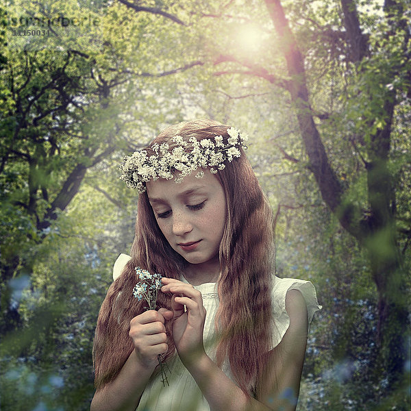 Kaukasisches Mädchen mit Blumenkrone im Wald