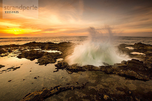 Meereswellen,  die bei Sonnenuntergang in Thor's Well brechen,  Cape Perpetua,  Oregon,  Vereinigte Staaten