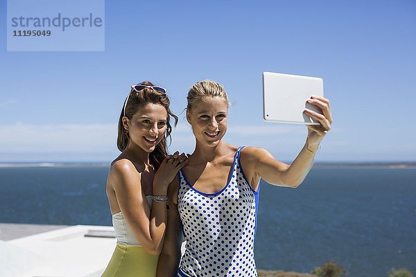 Weibliche Freunde,  die Selfie für sich selbst mit einem digitalen Tablett nehmen