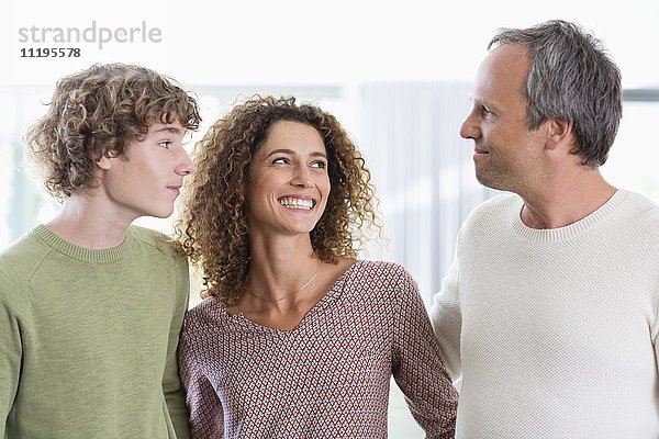 Porträt einer glücklichen Familie,  die zu Hause lächelt
