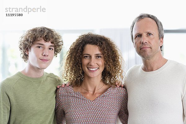 Porträt einer glücklichen Familie,  die zu Hause lächelt
