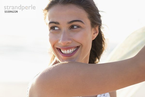 Attraktive junge Frau lächelnd am Strand