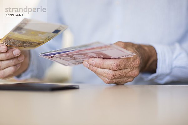 Mittelteilansicht eines älteren Mannes mit Geldscheinen