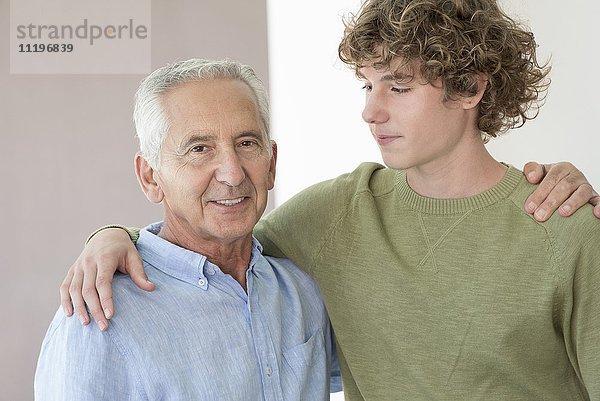 Porträt eines glücklichen älteren Mannes mit seinem Enkel im Teenageralter