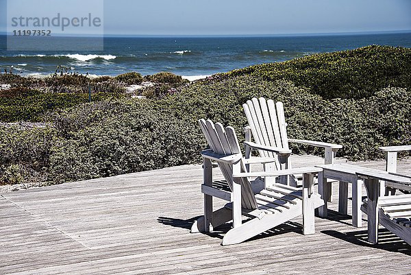 Adirondack Stühle an Deck im Resort am Meer
