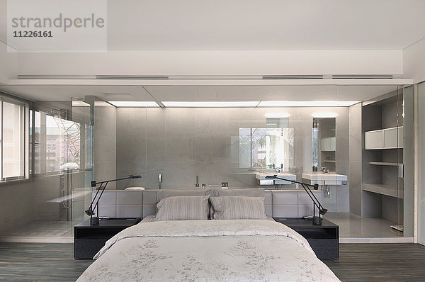 Modernes Schlafzimmer mit Glaswand zum Bad