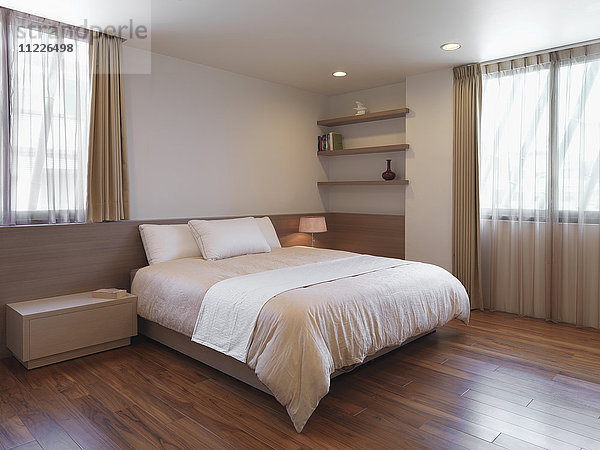 Einfaches,  minimalistisches Schlafzimmer mit Parkettboden