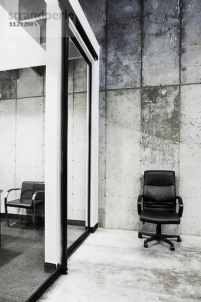 Detail eines einsamen Leder-Bürostuhls in einem modernen Bürogebäude