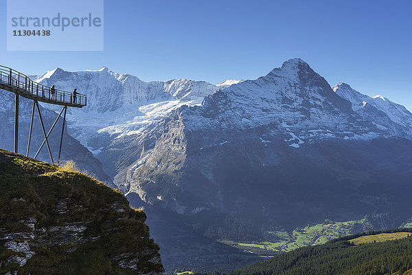 Gipfelweg und Aussichtsplattform mit dem Namen First Cliff Walk auf dem Gipfel des First oberhalb von Grindelwald,  Berner Oberland,  Schweiz. Oberhalb der Plattform die Berge Kleines Fiescherhorn (links) und Grosses Fiescherhorn und rechts Eiger und Jungfrau.