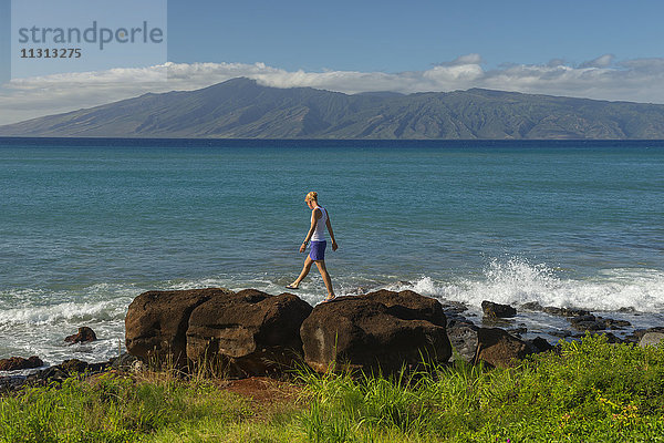 USA,  Vereinigte Staaten,  Amerika,  Hawaii,  Maui,  Kaanapali,  Mädchen,  das auf den Klippen spazieren geht,  mit der Insel Lanai im Hintergrund