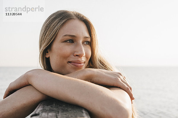 Porträt einer glücklichen jungen Frau am Meer