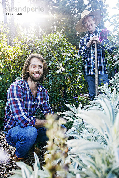 Lächelnde kaukasische Männer posieren im Garten