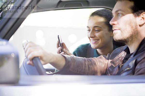 Paar hören Musik-Streaming auf dem Smartphone während der Fahrt
